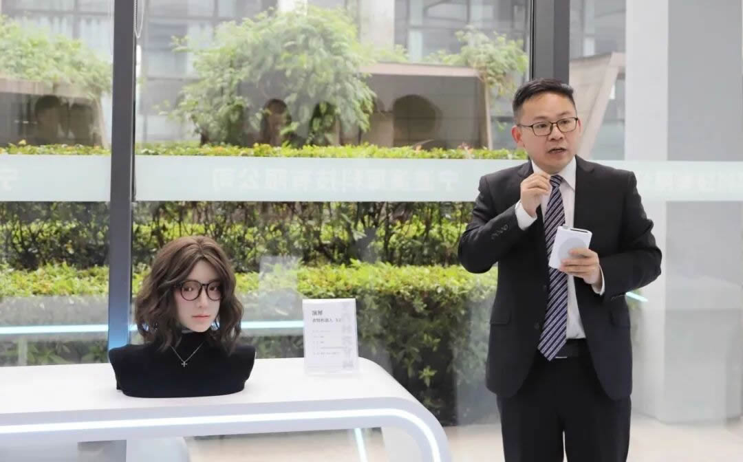 Yanxi Technology's team demonstrating the Yansyn-X2 emotional robot on stage during the April 29 launch event, with the robot's face expressing emotion live.